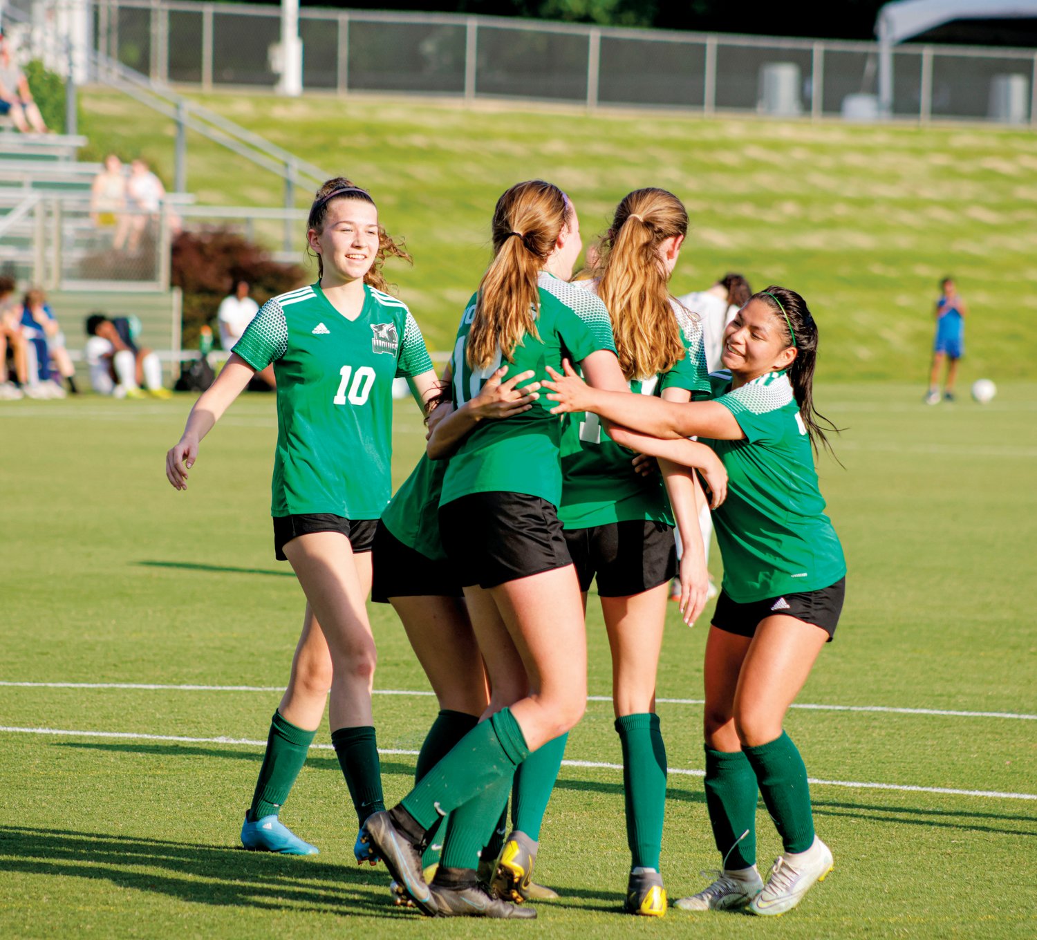 The Woods Charter women's soccer team celebrates with a group hug after sophomore Caroline Mitchell scored one of her two goals in the Wolves' 6-0 win over the Perquimans Pirates in the 4th round of the NCHSAA 1A playoffs last Thursday in Cary. The Wolves are undefeated on the season at 18-0-2.